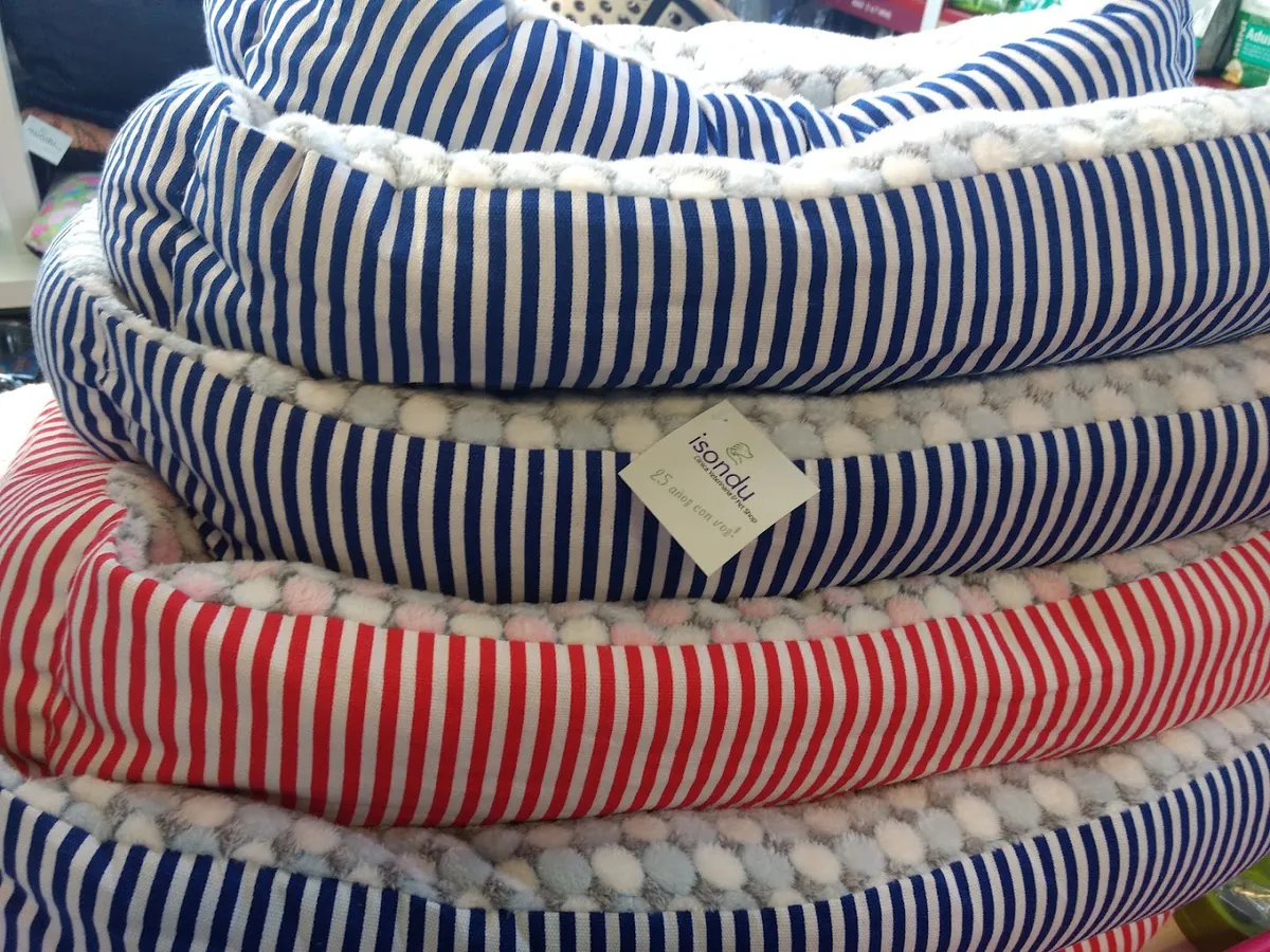 Camas para perros apiladas, a rayas azules, blancas y rojas