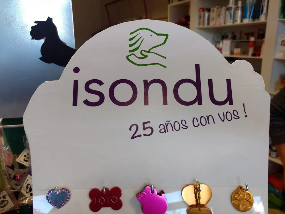 Cartel de Isondu con el logo del perro y la frase 25 años con vos, sobre chapitas para el collar